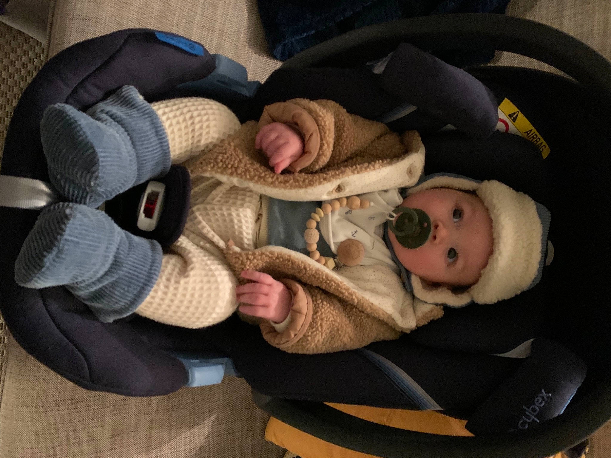 Léonard a rejoint le concours — aidez-le/la à gagner de superbes lots ! baby, baby_carriage, baby_products, baby_safety, baby_toddler_clothing, car_seat, cheek, child, comfort, gesture, headgear, headwear, lap, outerwear, person, personal_protective_equipment, sitting, sleep, smile, thumb