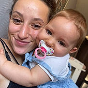 Eloa a rejoint le concours — aidez-le/la à gagner de superbes lots ! woman, baby, pacifier, smile, hug, indoor, closeup, face, child, person, clothing, dress, hair, skin, joy, affection, love, portrait, casual, family