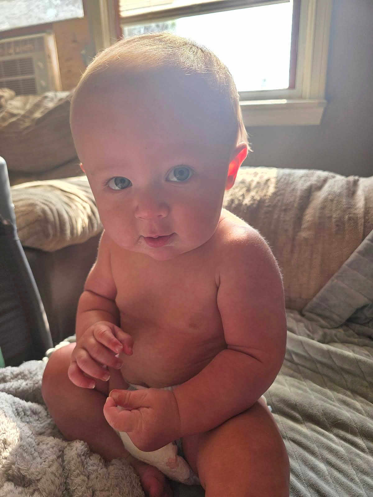 Brodi joined the competition — help win amazing prizes! baby, blanket, child, couch, curious, cute, diaper, face, fingers, hand, home, indoor, infant, natural_light, plump, portrait, sitting, skin, soft, window