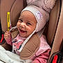 baby, child, car_seat, smiling, hat, knit_hat, pom_poms, pink_clothing, blanket, happy, cute, infant, seatbelt, safety, indoors, person, portrait, toddler, warm_clothing, closeup