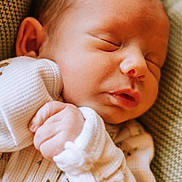 Weston is registered to the contest to win money with this photo: newborn, baby, sleeping, infant, closeup, cozy, white_clothing, patterned_outfit, hand, face, soft_light, blanket, texture, peaceful, resting, portrait, cute, child, young, indoors