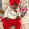 Ocean joined the competition — help win amazing prizes! baby, child, infant, red_bow, hello_kitty, red_pants, white_sweater, tulle_skirt, knit_booties, asthma_inhaler, floral_bedspread, bed, indoor, portrait, cute, serious_expression, sitting, person, headband, clothing