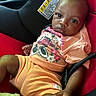 Ocean joined the competition — help win amazing prizes! baby, child, car_seat, seat_belt, peach_clothing, minnie_mouse, shorts, tshirt, socks, infant, cute, indoors, portrait, young_child, black_baby, sitting, closeup, expression, car_interior, warning_label