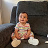 baby, casual, child, comfortable, cozy, curious_expression, cute, floor, furniture, gray_chair, happy, indoor, infant, person, portrait, sitting, soft_light, striped_clothing, white_shoes, young_child
