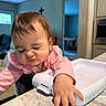 Ariella is registered to the contest to win money with this photo: baby, candid, child, countertop, cross, cute, doorway, expression, furniture, hand, highchair, home, indoor, kitchen, person, pink_clothing, scrunched_face, toddler, window, young_child