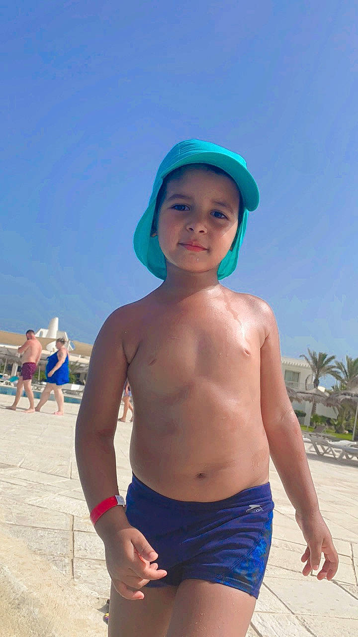 Ismail joined the competition — help win amazing prizes! abdomen, azure, barechested, beach, blue, blurred, cap, chest, electric_blue, fun, headwear, leisure, muscle, people_on_beach, person, sky, swimwear, toddler, travel, trunk