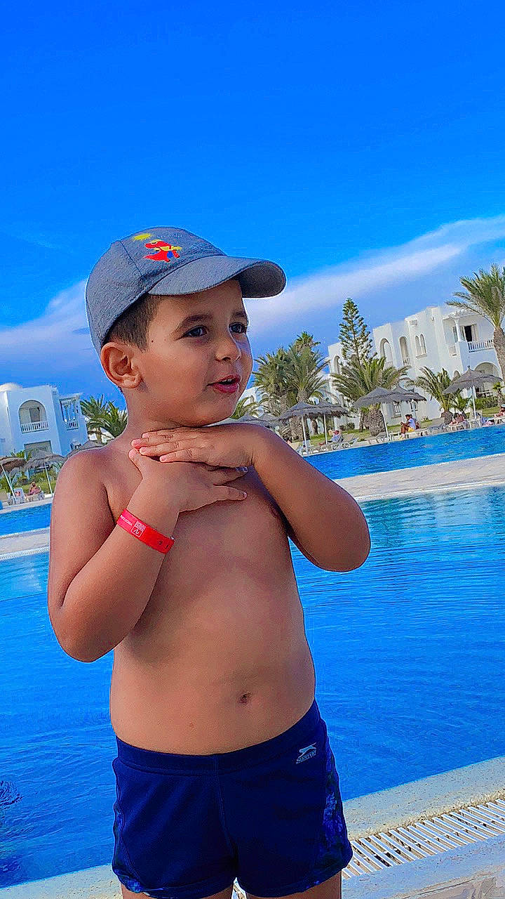 Ismail joined the competition — help win amazing prizes! arm, azure, blue, chest, cloud, elbow, electric_blue, fun, gesture, happy, headwear, joint, leisure, palm_tree, person, shoulder, sky, summer, swimming_pool, swimwear