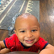 Bryson joined the competition — help win amazing prizes! toddler, child, smile, red_shirt, anchor_pattern, face, indoor, wooden_floor, rug, happy, person, baby, cute, portrait, home, flooring, clothing, hand, expression, young_child