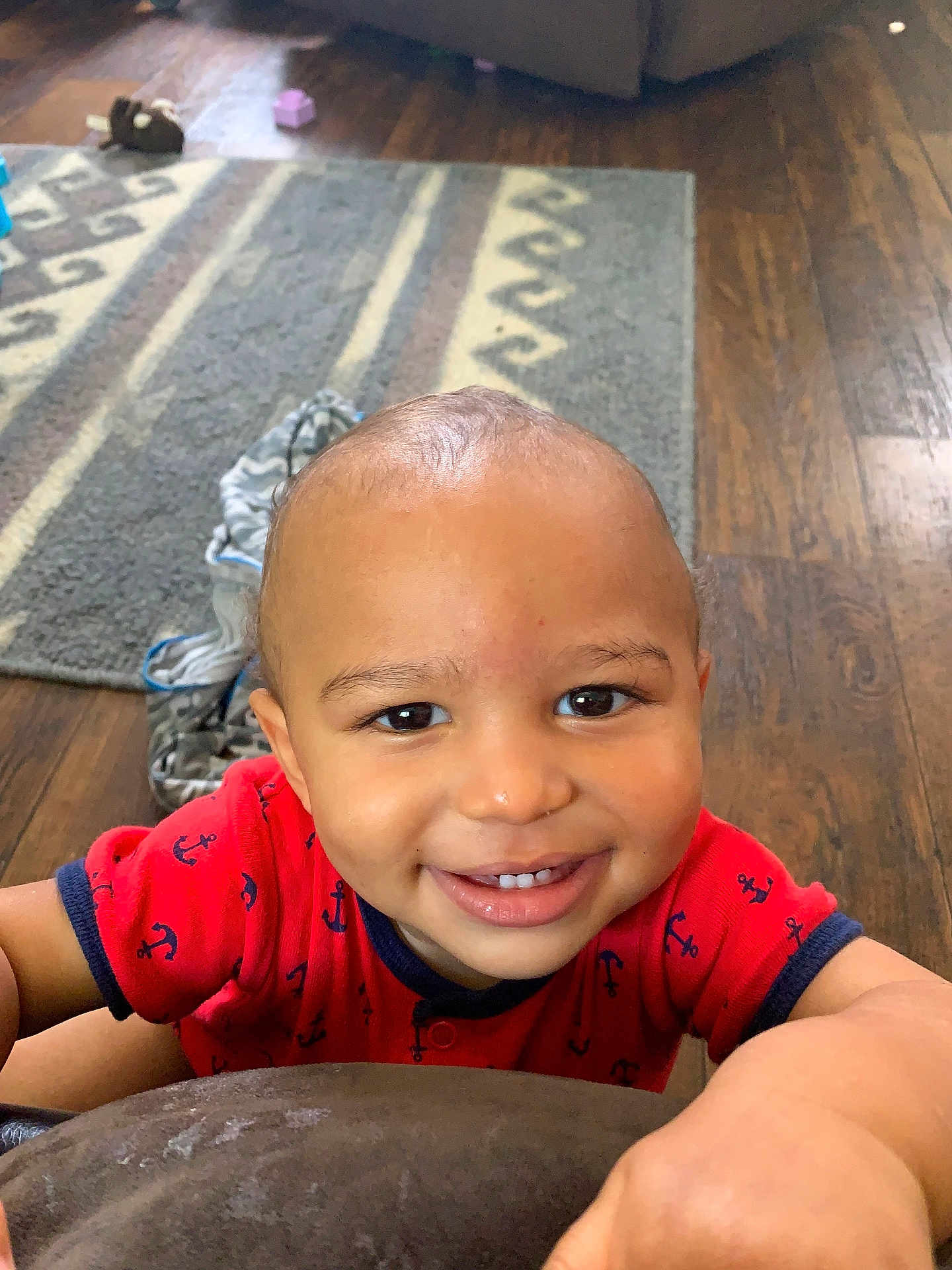 Bryson joined the competition — help win amazing prizes! toddler, child, smile, red_shirt, anchor_pattern, face, indoor, wooden_floor, rug, happy, person, baby, cute, portrait, home, flooring, clothing, hand, expression, young_child