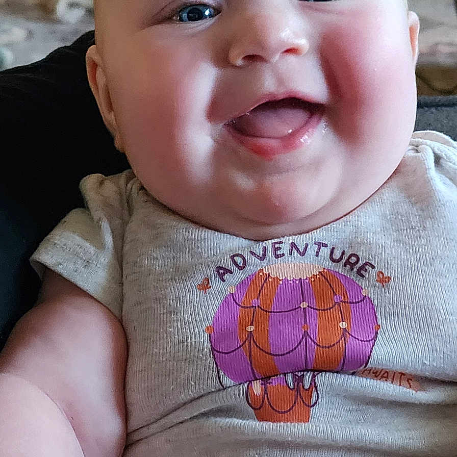 Gwyneth joined the competition — help win amazing prizes! applique, baby, babylaughing, bodypart, clothing, face, happy, head, laughing, mouth, newborn, pattern, person, photography, portrait, sitting, smile, t_shirt, teeth, toy