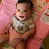 Kailani joined the competition — help win amazing prizes! baby, child, infant, smile, happy, cute, onesie, animal_print, pink, cushion, seat, patterned, indoor, portrait, face, skin, hand, leg, hair, comfort