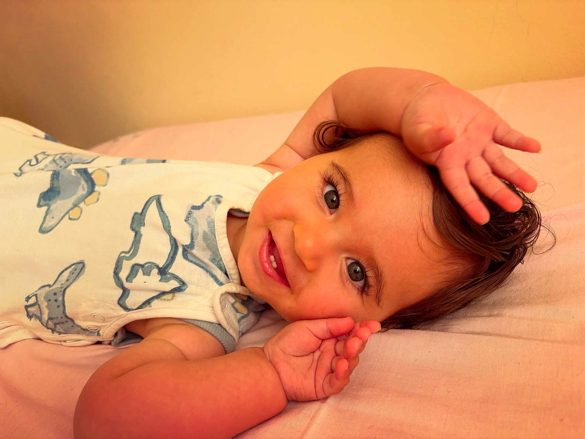Tommy joined the competition — help win amazing prizes! baby, smiling, infant, lying_down, white_outfit, animal_print, blue, pink_background, cute, happy, child, portrait, face, hands, skin, hair, eyes, teeth, playful, person