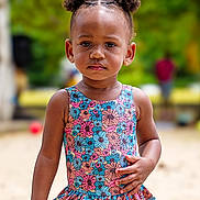 Naélyah participe au concours pour gagner de l'argent avec cette photo : toddler, child, swimsuit, floral_pattern, outdoor, sand, hair_puffs, serious_expression, summer, playground, person, skin, earrings, standing, daylight, nature, blurred_background, colorful, portrait, young_child