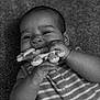 baby, black_and_white, carpet, chewing, child, close_up, cute, face, giraffe_toy, grainy_texture, hands, happy, head, indoor, infant, lying_down, portrait, smiling, striped_clothing, toy
