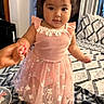 Avery is registered to the contest to win money with this photo: adult_hand, baby, bed, bedding, bedroom, blanket, child, cute, dress, eyes, face, fashion, home, indoors, infant, pink_dress, portrait, ruffles, smiling, standing