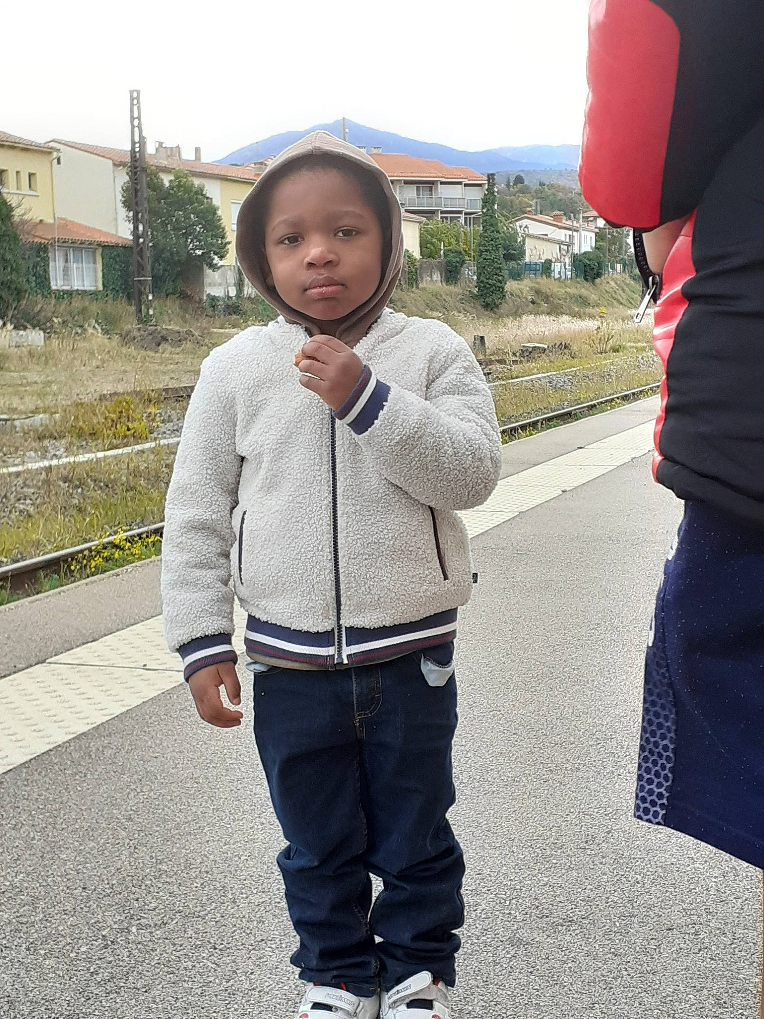 Aliou participe au concours pour gagner de l'argent avec cette photo : asphalt, child, cool, denim, electric_blue, fun, gesture, hairstyle, pattern, pedestrian, person, plant, public_space, sky, sleeve, standing, t_shirt, toddler, travel, uniform