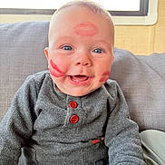Thélyo a rejoint le concours — aidez-le/la à gagner de superbes lots ! baby, blue_eyes, buttons, close_up, clothing, couch, cushion, face, hand, happy, indoor, infant, kiss_marks, lipstick_marks, portrait, rosy_cheeks, sitting, smiling, sweater, window