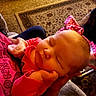 Ebony is registered to the contest to win money with this photo: baby, sleeping, infant, pink_clothing, hand, indoor, carpet, patterned_rug, person, cozy, soft_lighting, closeup, cute, newborn, resting, comfort, child, family, warmth, portrait