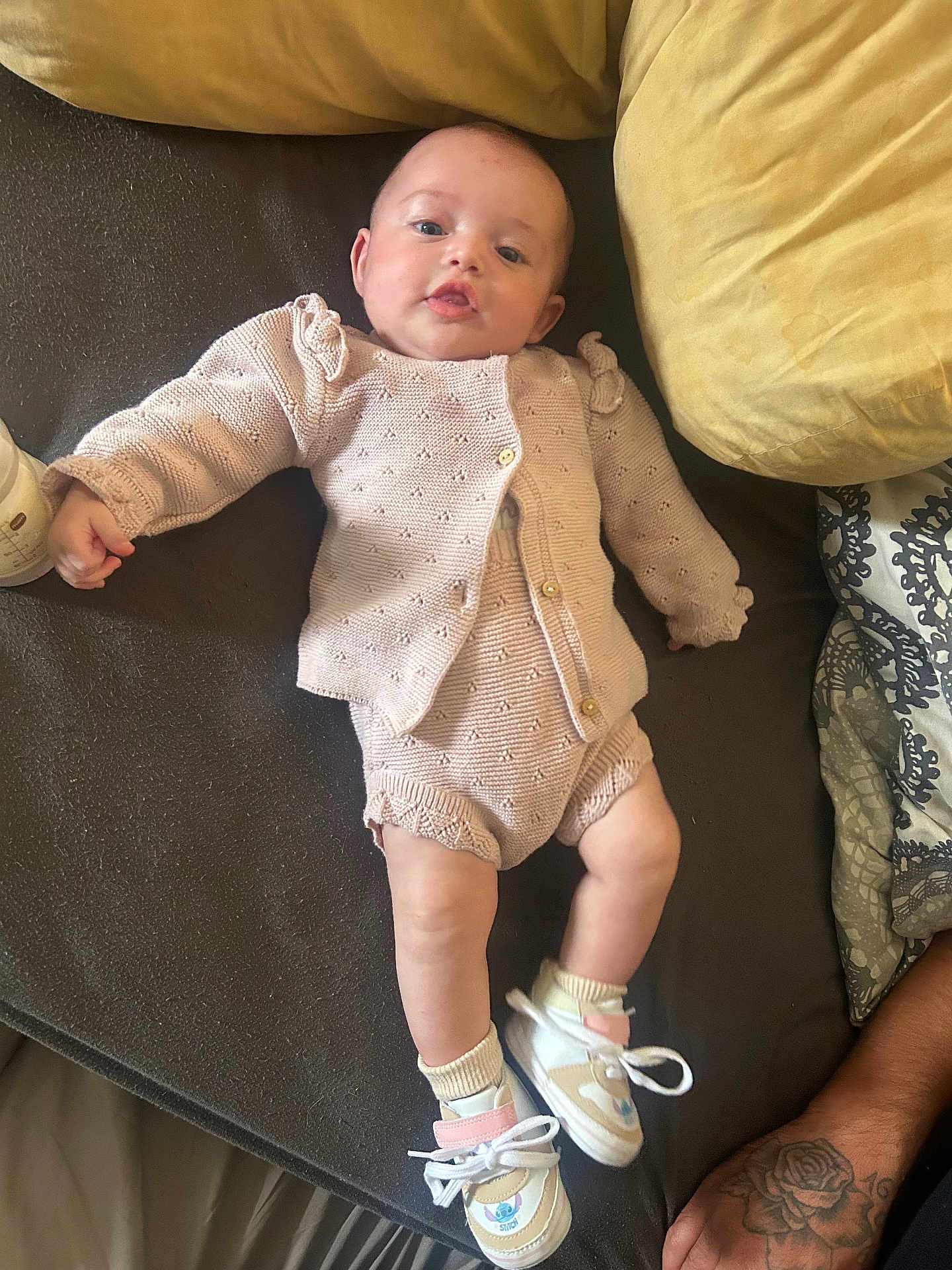 Leonie participe au concours pour gagner de l'argent avec cette photo : baby, infant, knitted_clothing, sneakers, couch, cushion, tattoo, arm, person, indoor, relaxing, cute, small_shoes, sitting, child, portrait, cozy, soft_fabric, baby_bottle, casual