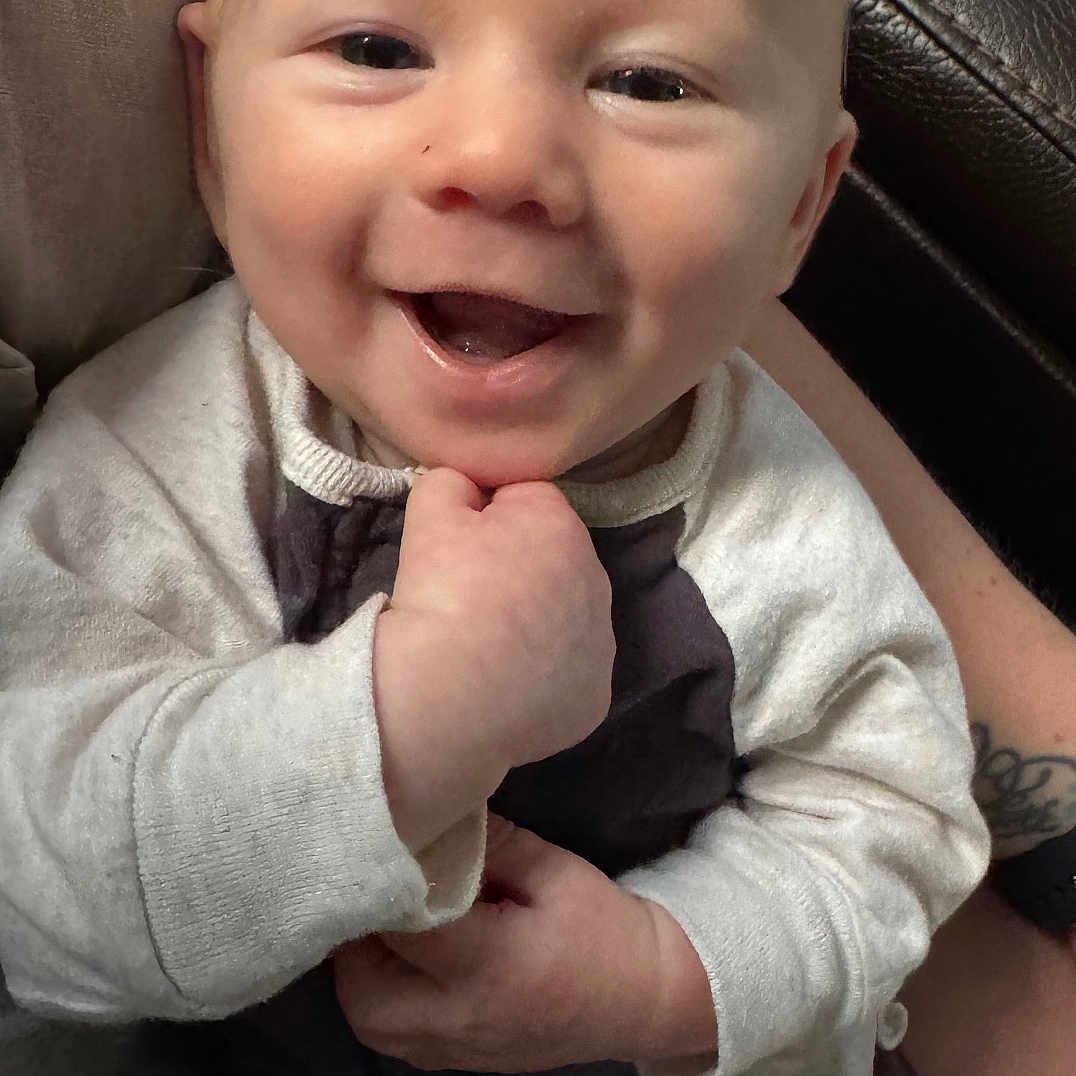 Ezra joined the competition — help win amazing prizes! accessories, baby, babylaughing, clothing, coat, cushion, face, formalwear, happy, head, homedecor, jacket, laughing, newborn, person, photography, portrait, sitting, smile, tie