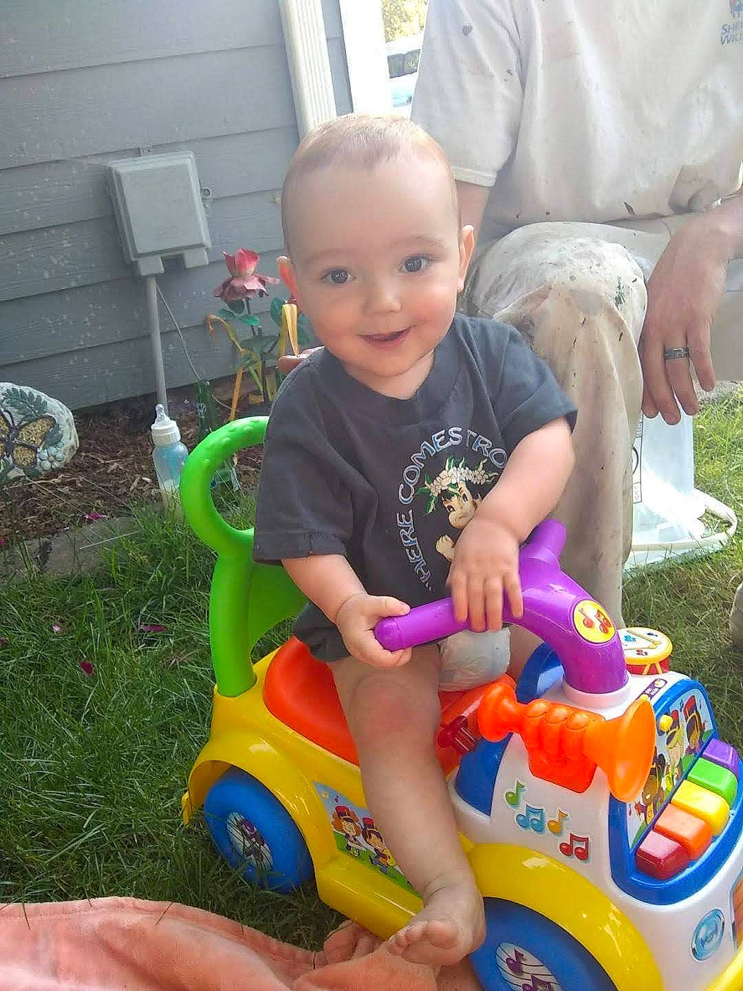Luis joined the competition — help win amazing prizes! baby, baby_toddler_clothing, child, event, fun, grass, happy, joy, lap, person, play, recreation, riding_toy, shorts, sitting, smile, tire, toddler, toy, toy_vehicle