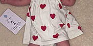 Charly a rejoint le concours — aidez-le/la à gagner de superbes lots ! baby, infant, dress, hearts, blanket, crib, milestone_card, lying_down, wide_eyes, alert, cute, person, child, one_month, red_hearts, white_dress, skin, legs, arms, indoors