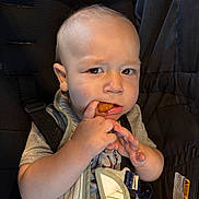 Carson joined the competition — help win amazing prizes! toddler, child, car_seat, food, nugget, bib, clothing, indoor, seatbelt, young_child, expression, hand, face, person, baby, apparel, sitting, curious, snack, casual