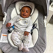 Amir is registered to the contest to win money with this photo: baby, infant, bouncer, gray, pajamas, cap, star, toy, indoor, child, cute, smiling, face, hands, feet, fabric, cushion, seat, happy, portrait