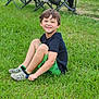 child, boy, grass, smiling, outdoor, greenery, casual_clothing, shorts, tshirt, shoes, people, spectators, baseball, sports, field, fence, chair, game, fun, daytime