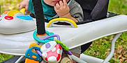Lucas joined the competition — help win amazing prizes! baby, child, clothing, colorful, curious, cute, expression, face, grass, green, hand, infant, nature, outdoor, playtime, seat, sitting, toy, walker, young_child