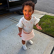 Egypt joined the competition — help win amazing prizes! child, toddler, smiling, happy, outdoor, driveway, sidewalk, grass, car, portrait, standing, curly_hair, dress, skirt, socks, shoes, daylight, suburban, person, face