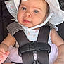 baby, child, car_seat, harness, hat, white_clothing, pink_tulle, infant, cute, smiling, face, hand, sitting, safety, seatbelt, red_button, straps, closeup, indoors, person