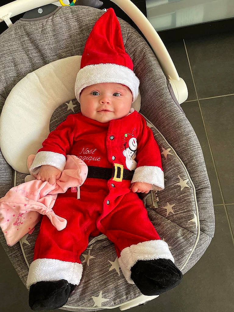 émilie a rejoint le concours — aidez-le/la à gagner de superbes lots ! baby, baby_carriage, baby_products, baby_sleeping, baby_toddler_clothing, cap, christmas, comfort, costume_hat, fictional_character, headwear, holiday, lap, leg, outerwear, person, santa_claus, sleeve, smile, sock