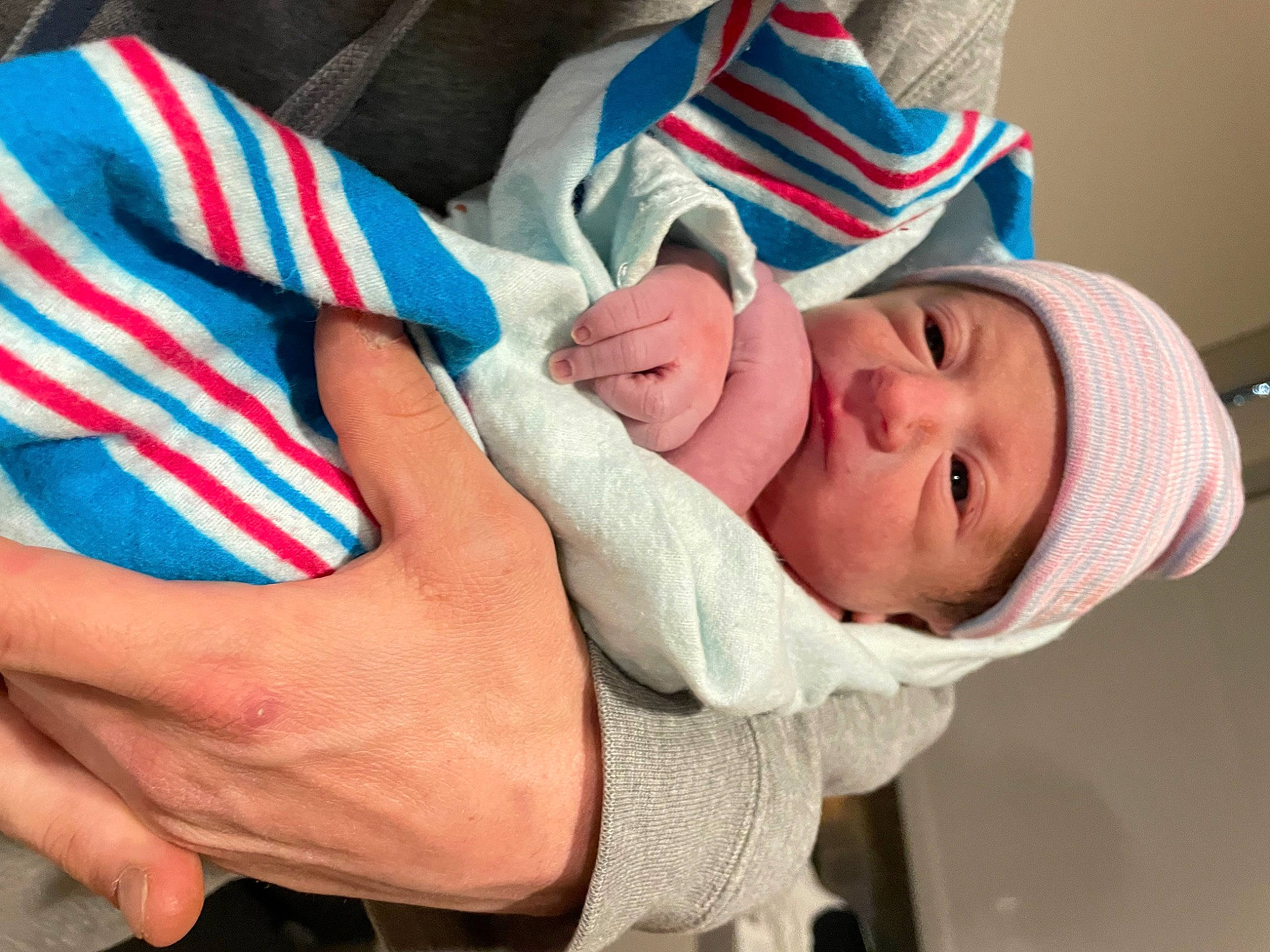 Asher is registered to the contest to win money with this photo: baby, baby_products, baby_toddler_clothing, comfort, eye, eyelash, face, finger, gesture, hand, happy, hat, headwear, linens, nail, person, sleeve, smile, textile, thumb