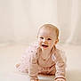 baby, child, crawling, smiling, pink_dress, long_sleeves, floor, carpet, indoor, portrait, cute, happy, young_child, infant, person, toddler, light_skin, blonde_hair, soft_lighting, neutral_background