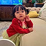 Lillian is registered to the contest to win money with this photo: toddler, child, red_cardigan, green_dress, couch, living_room, plant, cabinet, television, animation, woman, overalls, carpet, pillow, furniture, indoor, portrait, curly_hair, cute, home