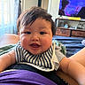 baby, child, infant, smiling, happy, portrait, indoors, bedroom, bib, striped_clothing, short_hair, face, eyes, mouth, arms, television, furniture, curtains, bed, photography