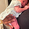 Tyanna joined the competition — help win amazing prizes! newborn, baby, infant, child, sleepy, face, hand, adult, parent, holding, lap, onesie, clothing, indoor, portrait, cuddly, sitting, warm_lighting, family, caregiving