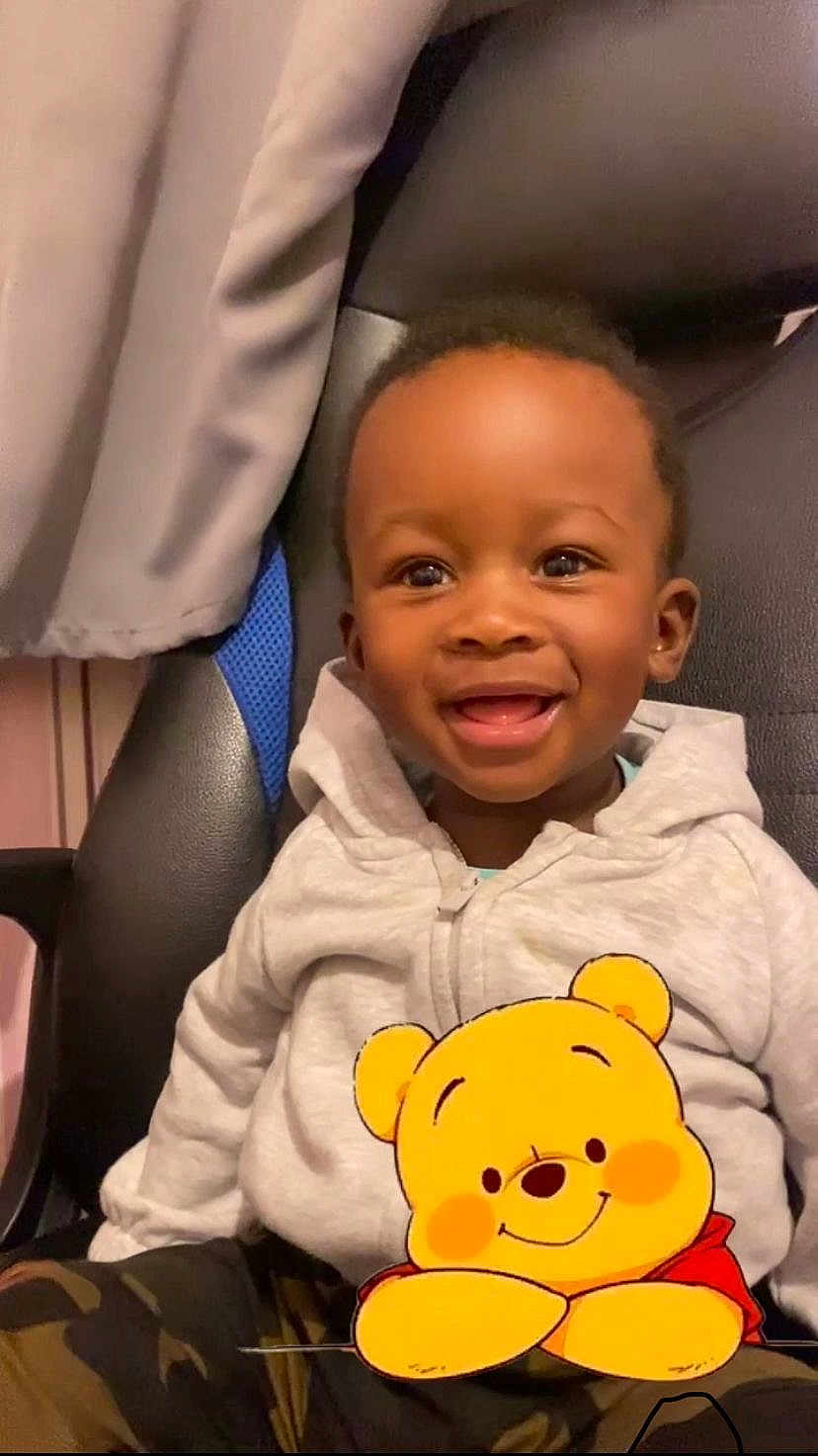 Rayan Hakim a rejoint le concours — aidez-le/la à gagner de superbes lots ! toddler, child, smiling, hoodie, winnie_the_pooh, graphic, chair, indoor, happy, cute, camo_pants, young_child, portrait, seated, black_hair, casual_clothing, playful, cozy, expression, person