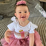 Ava joined the competition — help win amazing prizes! baby, celebration, child, couch, cute, flower, girl, happy, headband, indoor, living_room, one_year_old, pink, plush, portrait, sitting, smiling, soft_texture, tutu_skirt, white_shirt