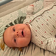 Pablo participe au concours pour gagner de l'argent avec cette photo : baby, infant, child, onesie, striped_clothing, hearts, love, cuddle, bedspread, pattern, smiling, happy, lying_down, face, head, skin, cute, indoors, person, closeup