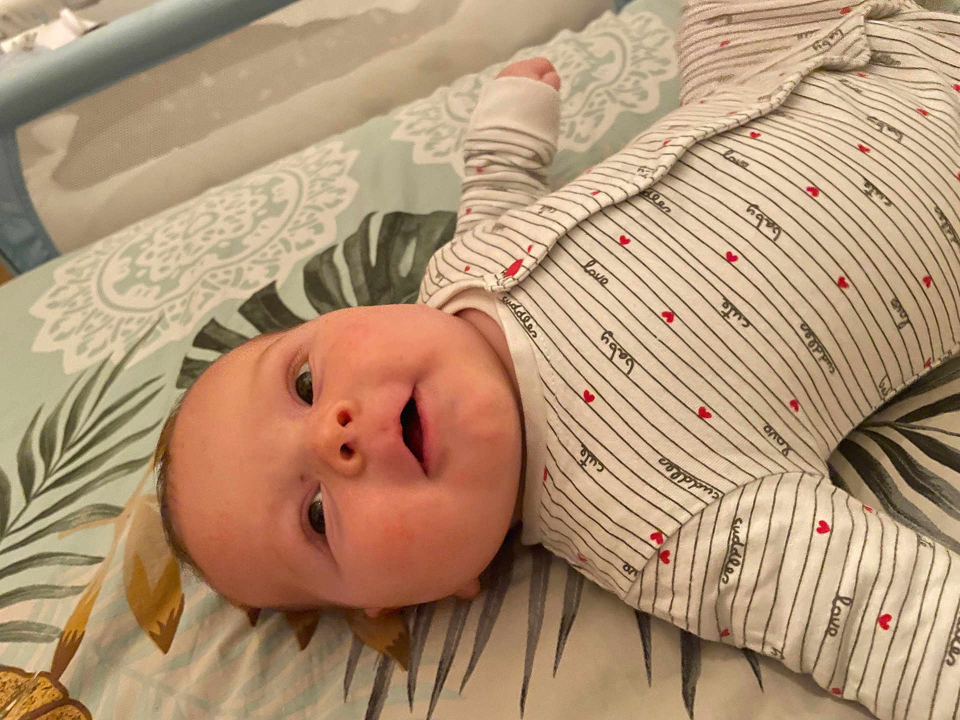 Pablo participe au concours pour gagner de l'argent avec cette photo : baby, infant, child, onesie, striped_clothing, hearts, love, cuddle, bedspread, pattern, smiling, happy, lying_down, face, head, skin, cute, indoors, person, closeup