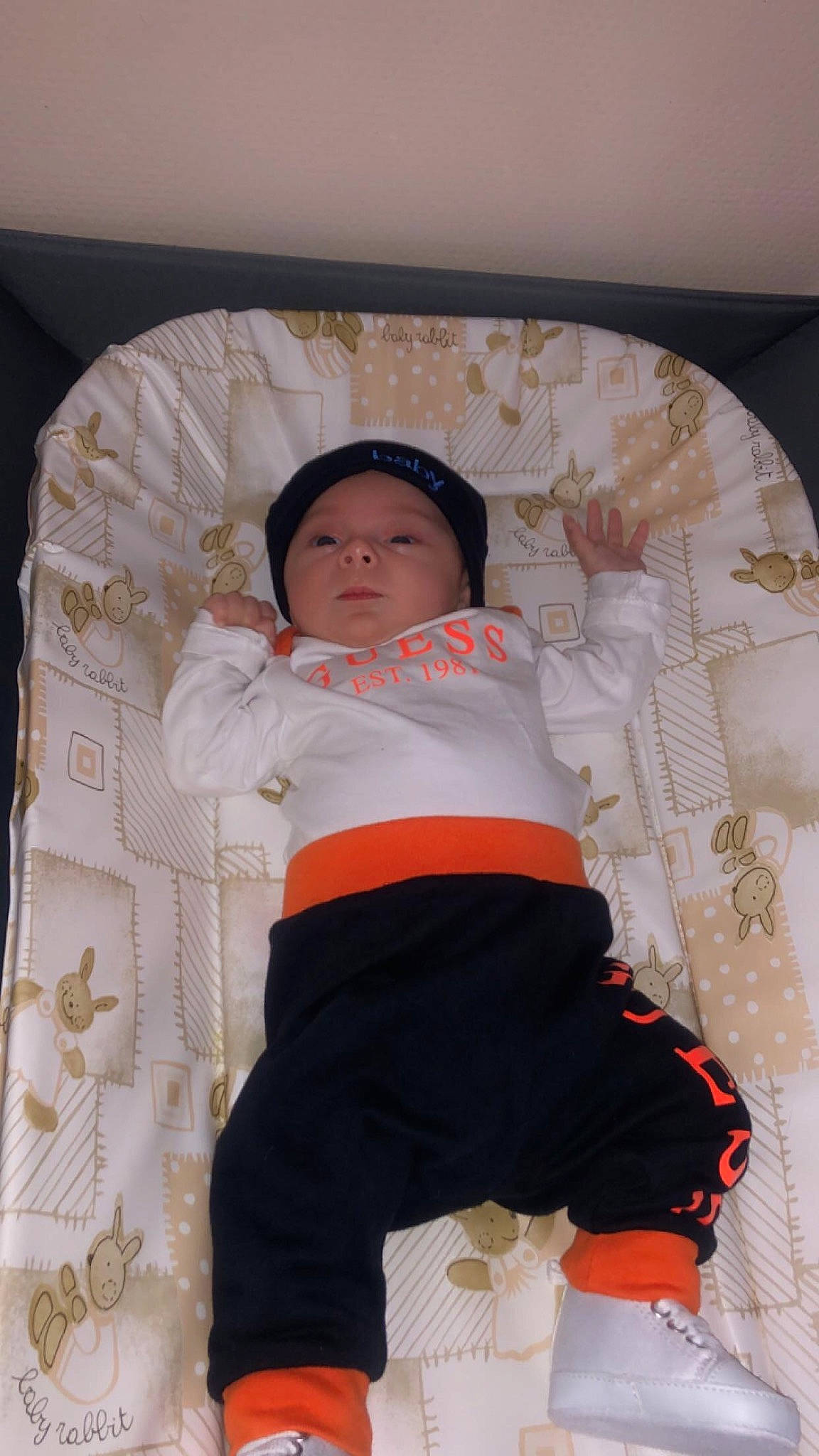 Mylann participe au concours pour gagner de l'argent avec cette photo : abdomen, baby, baby_products, baby_sleeping, baby_toddler_clothing, child, comfort, flooring, fun, headwear, human_leg, linens, pattern, peach, person, pink, room, sitting, sleeve, t_shirt