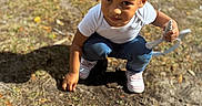 Kaydance is registered to the contest to win money with this photo: child, toddler, outdoor, dirt, grass, sunlight, shadow, curly_hair, white_shirt, blue_jeans, pink_shoes, garden_tool, playing, crouching, person, nature, daylight, ground, parked_car, young_child