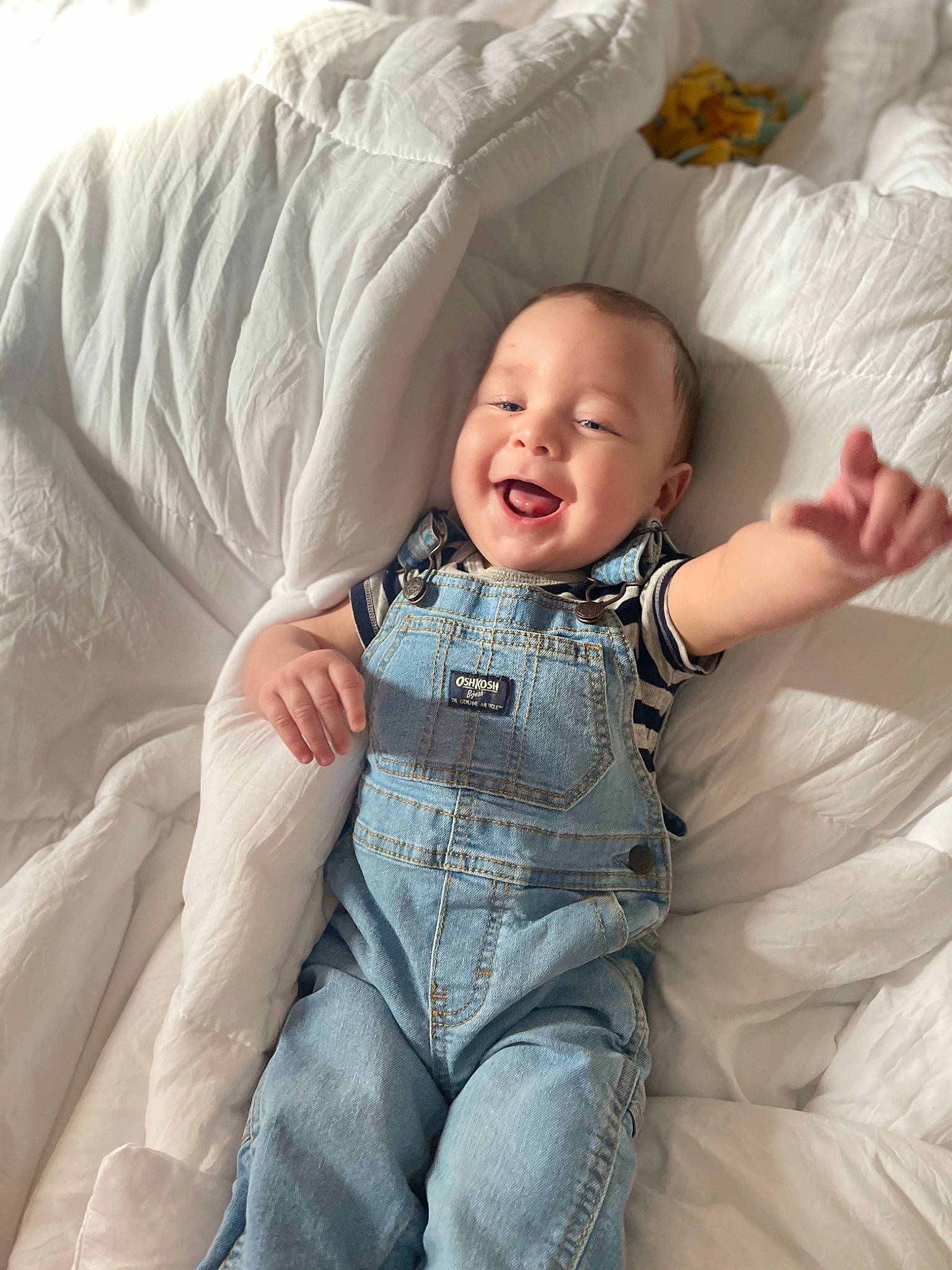 Leonidas is registered to the contest to win money with this photo: baby, baby_toddler_clothing, bed, comfort, eye, finger, flash_photography, gesture, hairstyle, hand, happy, head, iris, leg, mouth, person, skin, sleeve, smile, textile
