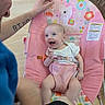 Fiona is registered to the contest to win money with this photo: baby, child, smile, person, arm, tattoo, baby_seat, unicorn, pink, pacifier, floor, couch, furniture, happy, indoor, clothing, hand, playful, infant, seatbelt