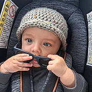 Angel Santos is registered to the contest to win money with this photo: baby, child, car_seat, knitted_hat, sunglasses, hands, blue_eyes, cute, infant, seat_belt, clothing, portrait, indoor, person, young_child, closeup, curious, playing, seat, safety