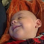 Angelemmanuel is registered to the contest to win money with this photo: baby, smiling, sleeping, blanket, red_clothing, striped_clothing, face, head, ear, cheek, infant, child, cozy, soft_texture, closeup, resting, cute, peaceful, indoors, portrait