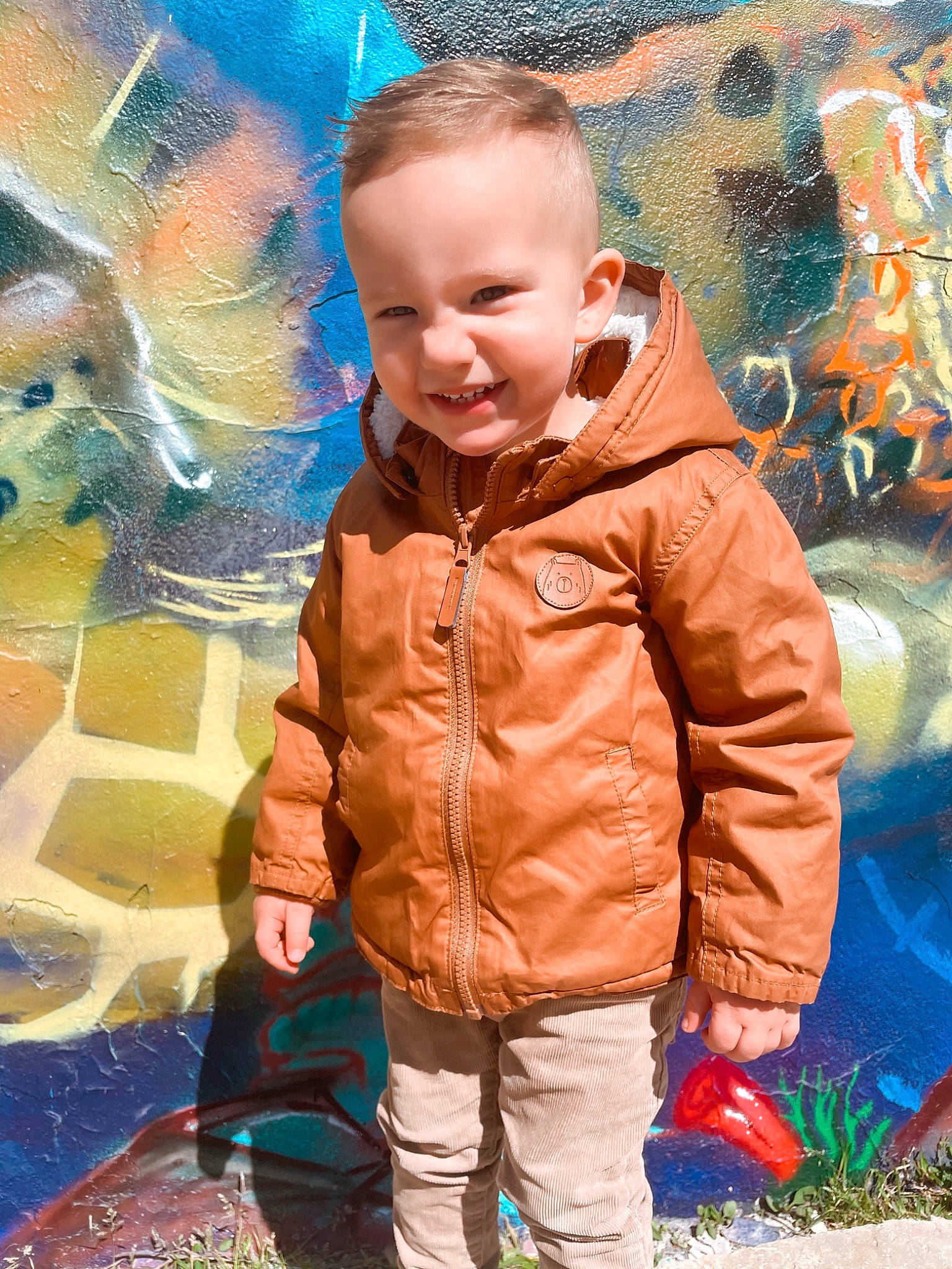 Many participe au concours pour gagner de l'argent avec cette photo : art, child, cool, electric_blue, event, fun, grass, happy, jacket, joy, leaf, leisure, orange, outerwear, people_in_nature, person, public_space, recreation, smile, toddler