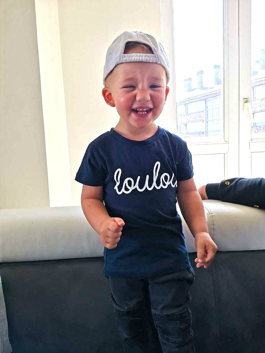 Many participe au concours pour gagner de l'argent avec cette photo : active_shirt, baby_toddler_clothing, cap, child, cool, couch, denim, dress, electric_blue, fashion_accessory, fun, happy, hat, headwear, joy, magenta, neck, person, sleeve, smile